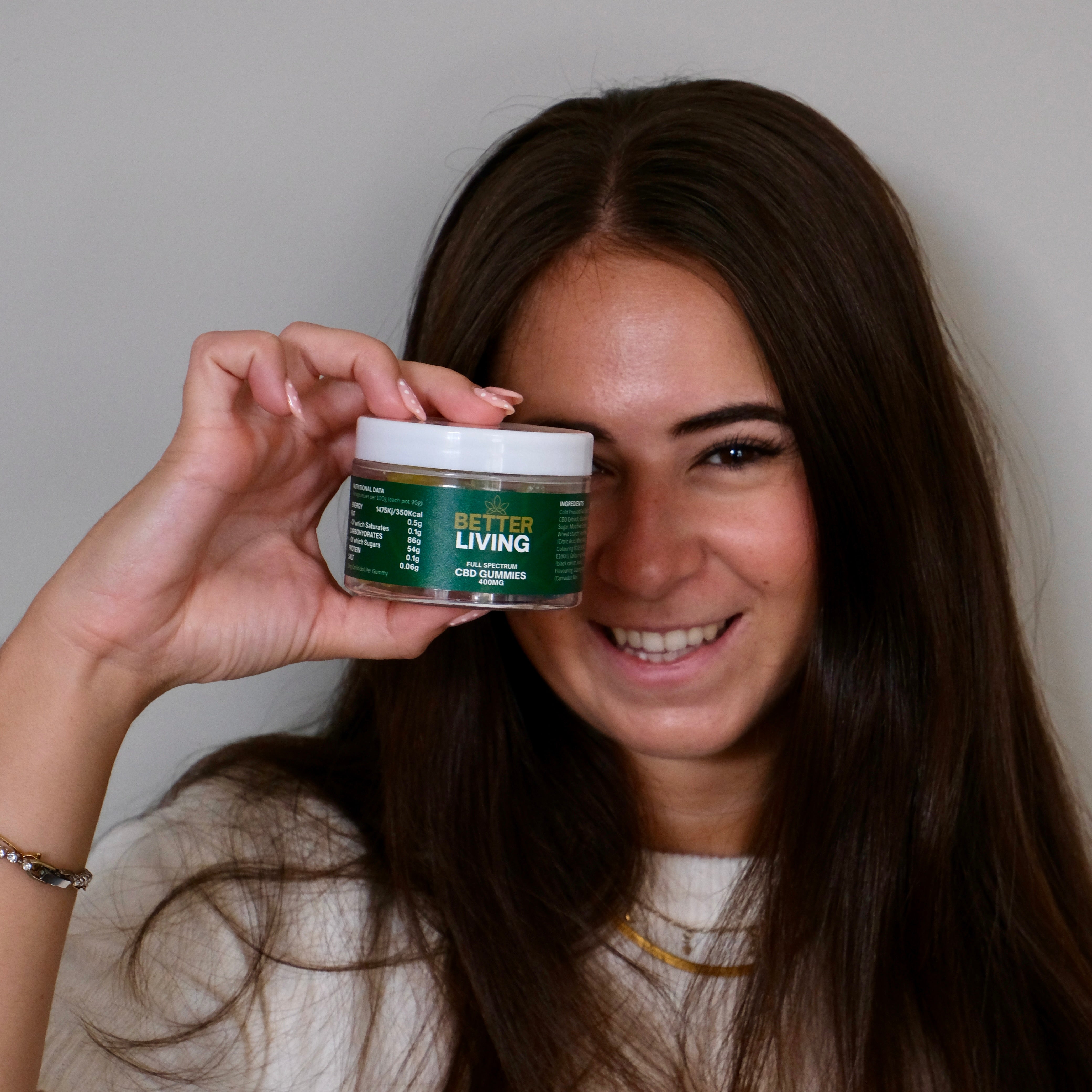 woman holding a pack of better living cbd gummies 